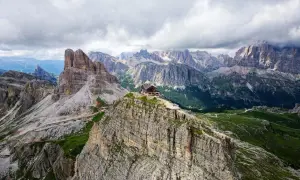 Un refuge de montagne perché sur un pic rocheux, au cœur des Dolomites en Italie. Un paysage spectaculaire de montagnes escarpées et de vallées verdoyantes.