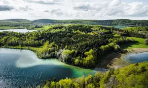 Paysage jurassien avec lacs et forêts verdoyantes, idéal pour une randonnée Jura 5 jours.