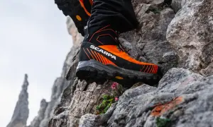 Des chaussures de randonnée Scarpa orange et noires, parfaites pour choisir son chemin sur les rochers escarpés.