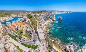 Vue panoramique de Bonifacio, Corse. La ville perchée sur les falaises blanches surplombe un port animé et une mer turquoise. Idéal pour visiter Bonifacio.