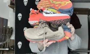 Trois paires de chaussures de trail colorées, empilées. Peut-on courir avec des chaussures de trail sur route ?