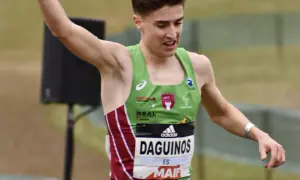 Le jeune athlète Etienne Daguinos, en pleine course, lève un bras victorieusement.