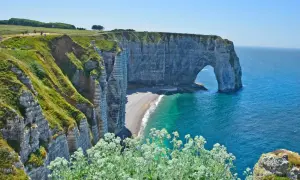 Falaises verdoyantes et arche rocheuse emblématique à Étretat, un paysage normand à couper le souffle, entre Fécamp et le littoral.