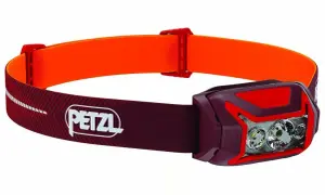 Lampe frontale Petzl rouge et orange, idéale pour choisir votre éclairage d'aventure.
