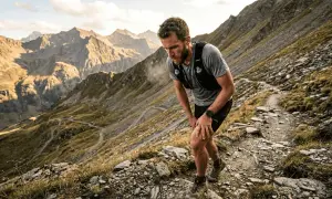 Patrick Bohard, un traileur, s'arrête sur un sentier rocailleux de montagne, le souffle court, le regard perdu dans les sommets.