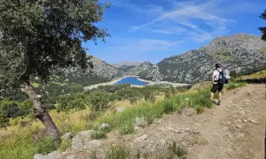 Randonneur contemplant le lac du Gorg Blau, un paysage emblématique du GR221 à Majorque.