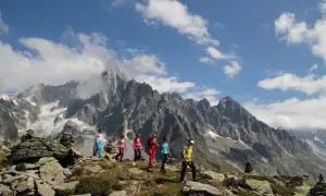 Groupe de randonneurs profitant d'une magnifique randonnée à Chamonix, avec des montagnes imposantes en arrière-plan.