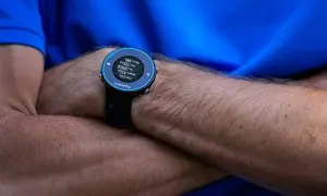 Montre Garmin Forerunner 620 au poignet d'un coureur, affichant distance, temps et calories.