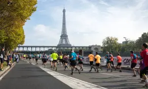 Course de marathon à Paris, avec la Tour Eiffel en arrière-plan. L'allure marathon 3h20 est visée par ces coureurs déterminés.