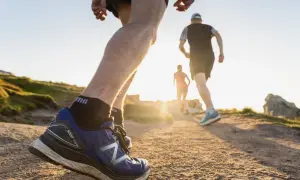 Coureurs sur un sentier de trail en Bretagne, profitant du soleil couchant sur la côte.
