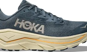 Chaussure de course Hoka bleu marine, avec semelle épaisse beige et détails orange. Le logo Hoka est bien visible. Parfaite pour le trail avec son drop 8mm.