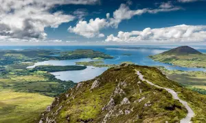 Sentier de randonnée Connemara, vue panoramique sur les lacs et les îles sous un ciel nuageux.