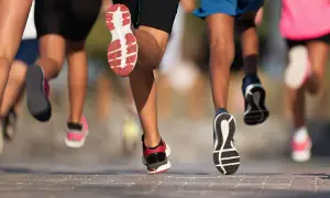 Des coureurs en action, leurs jambes et chaussures en mouvement. Une scène dynamique pour apprendre à courir.