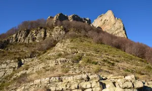 Vue spectaculaire des 3 becs, falaises rocheuses et arbres dénudés sous un ciel bleu intense.