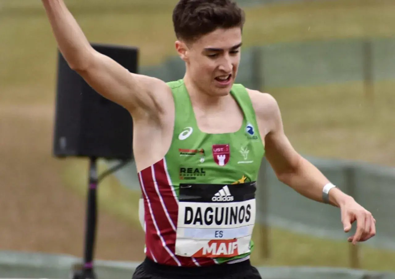 Le jeune athlète Etienne Daguinos, en pleine course, lève un bras victorieusement.