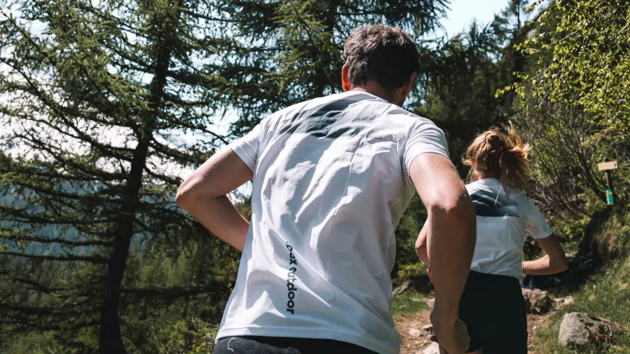 Couple en pleine course en forêt, profitant d'un moment de sport aérobie en pleine nature.