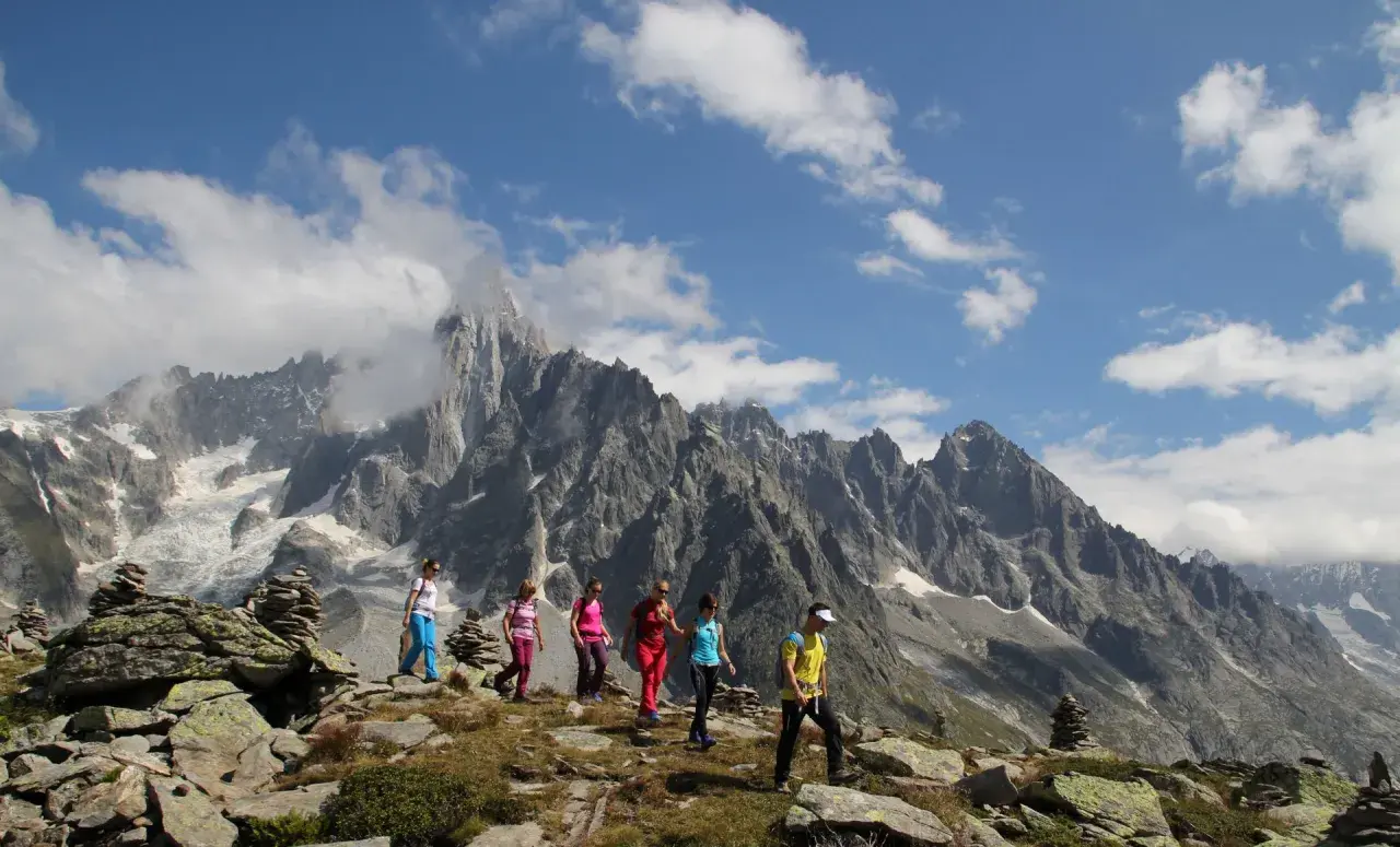 Groupe de randonneurs profitant d'une magnifique randonnée à Chamonix, avec des montagnes imposantes en arrière-plan.