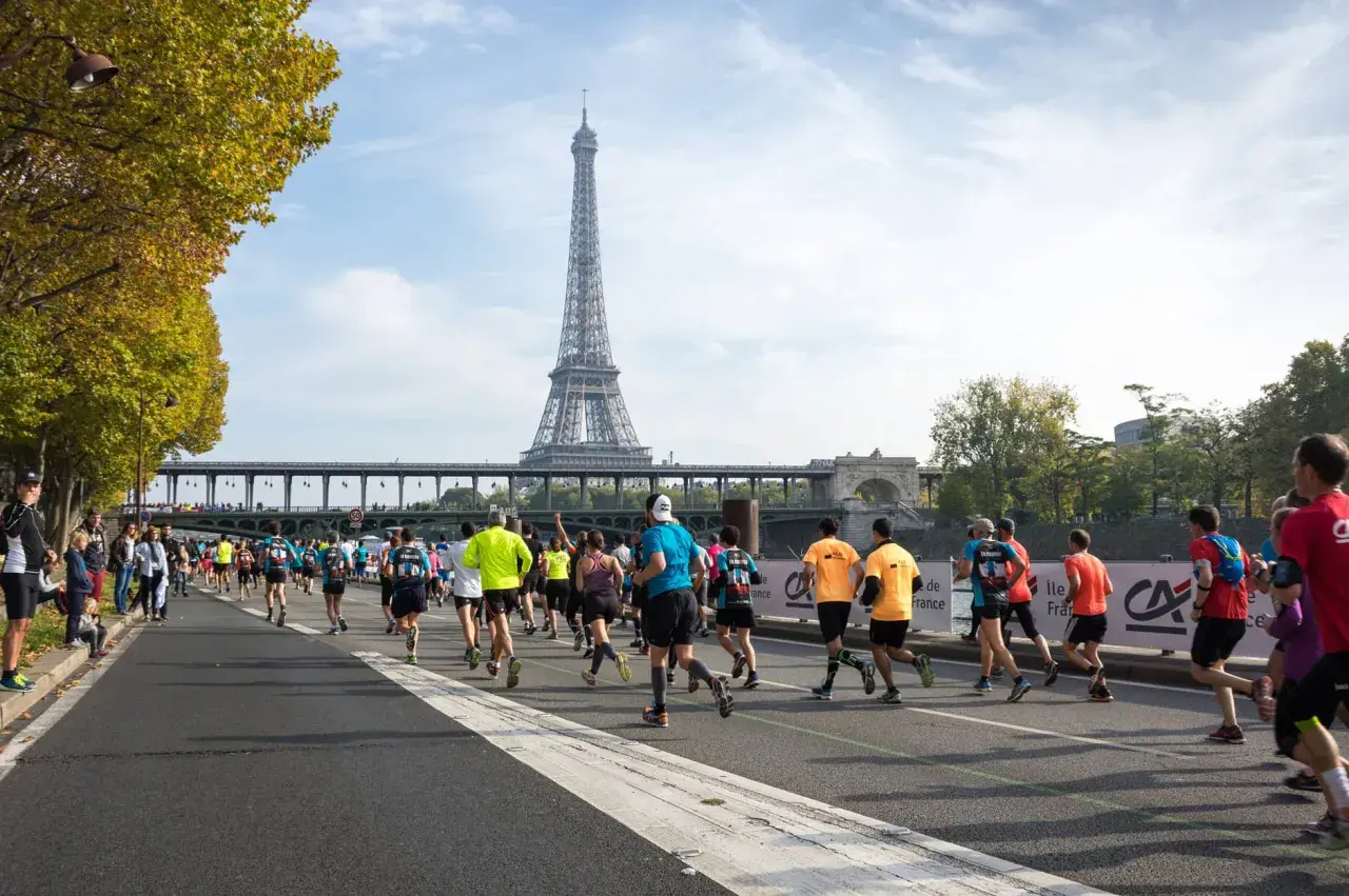 Course de marathon à Paris, avec la Tour Eiffel en arrière-plan. L'allure marathon 3h20 est visée par ces coureurs déterminés.