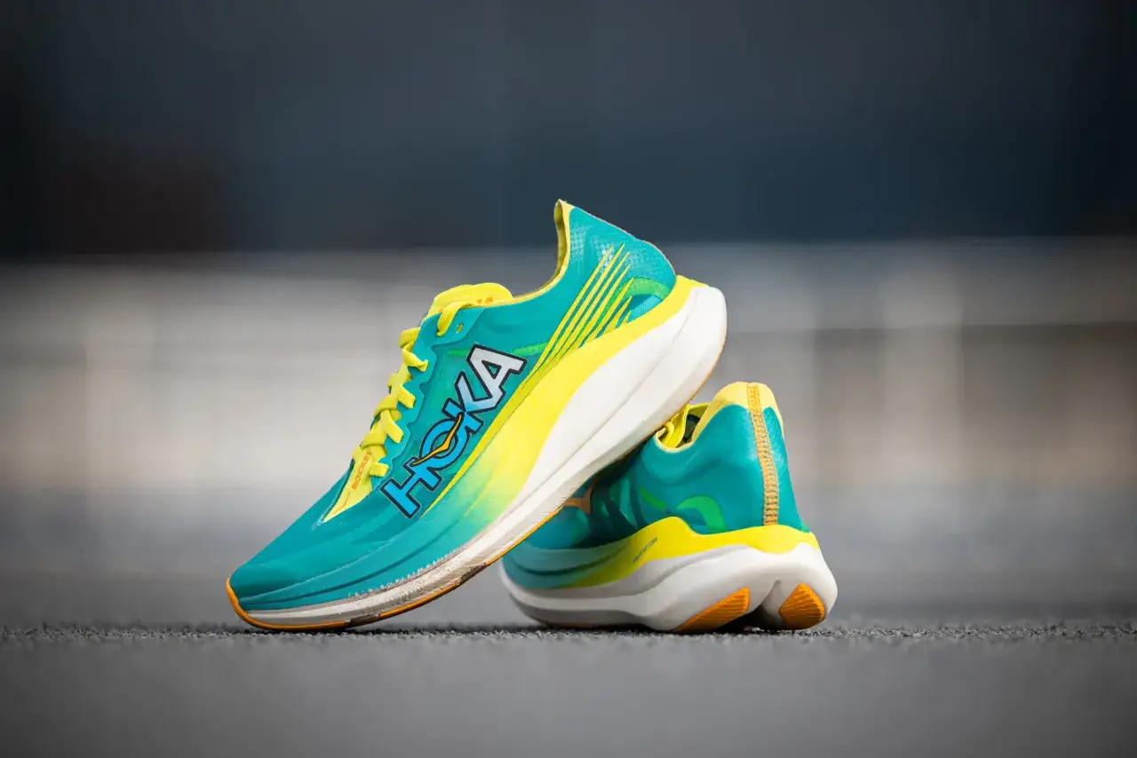 Paire de chaussures de course Hoka Rocket X 2, turquoise et jaune vif, pr&ecirc;tes pour un test de performance.