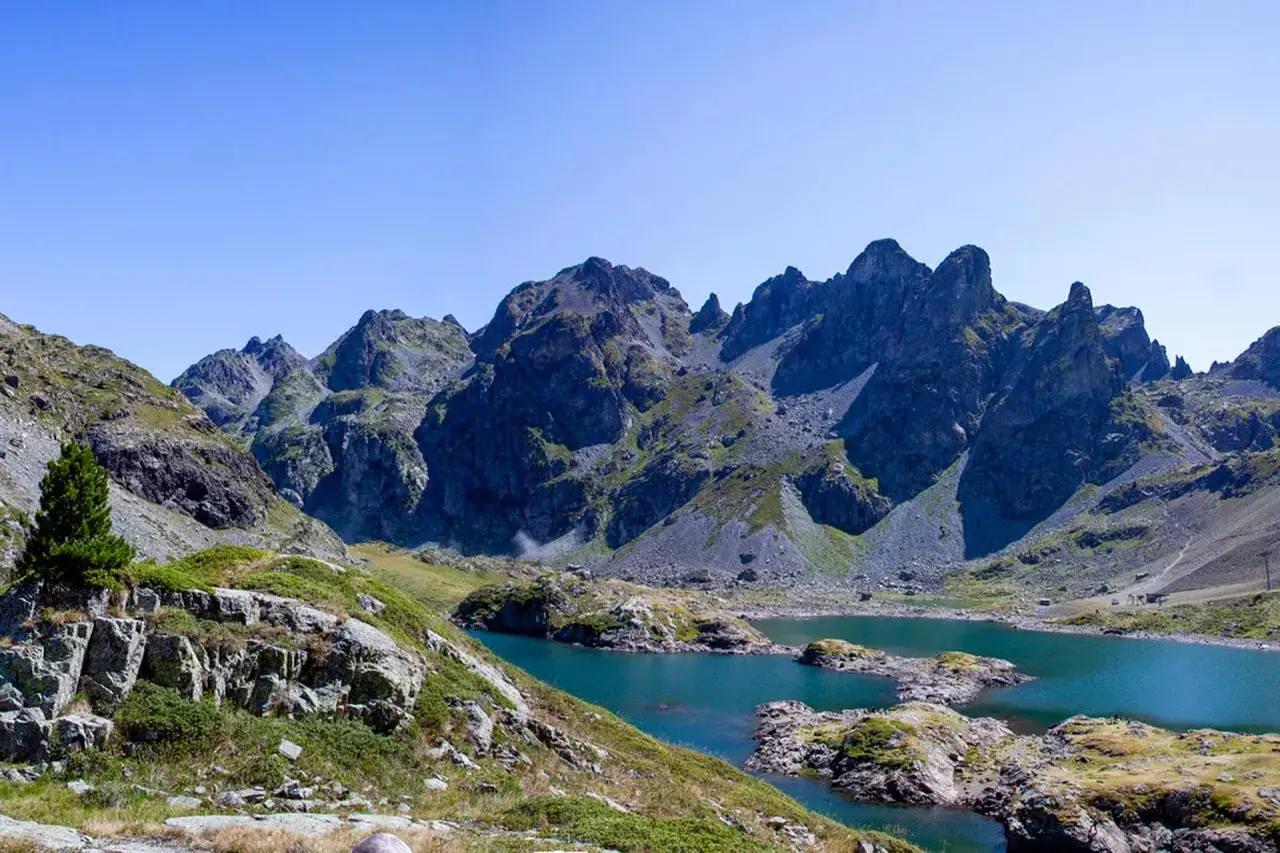 Vue panoramique du lac Robert, un joyau bleu entouré de montagnes rocheuses et de verdure.