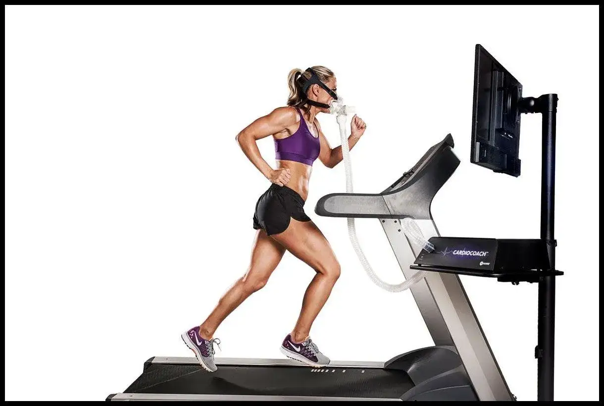 Athlète en plein effort sur tapis roulant, masque respiratoire connecté pour mesurer son VO2 max.