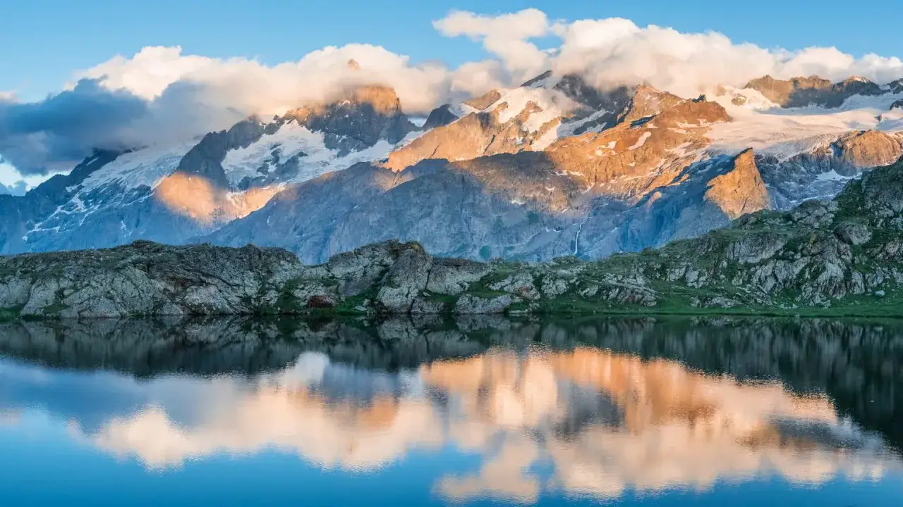Reflets d'un lac alpin sur des montagnes enneigées au lever du soleil. Parfait pour une randonnée Alpes 3 jours.