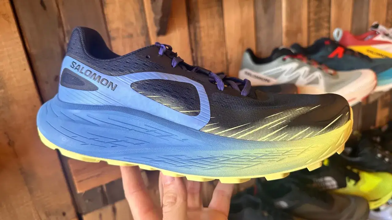Chaussure Salomon noire et bleue, avec une semelle &eacute;paisse jaune et bleue, offrant le hoka meilleur amorti pour vos courses.