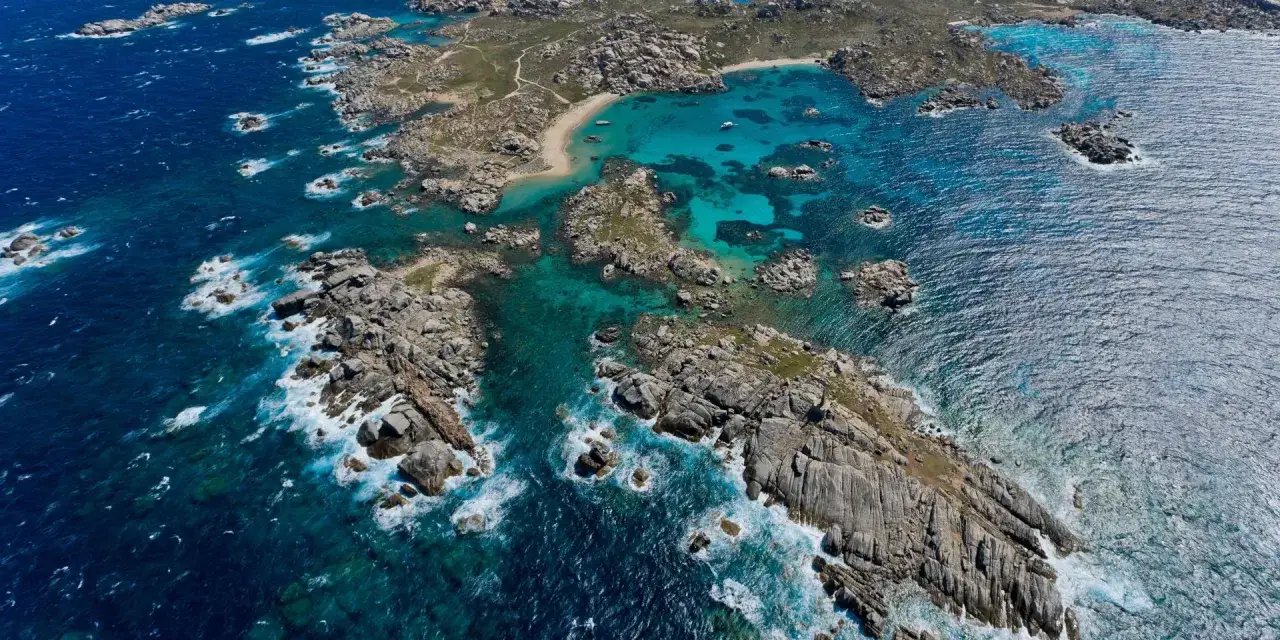 Vue aérienne de l'île Lavezzi, avec ses eaux turquoise cristallines, ses rochers granitiques et ses petites plages isolées.